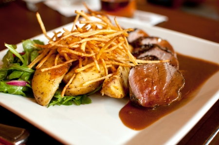 Gourmet beef frites with potatoes and saladの写真素材