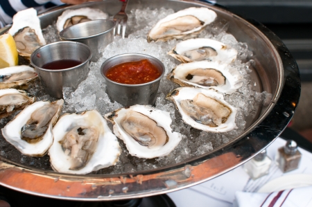 Oysters served raw with sauces and lemonの写真素材
