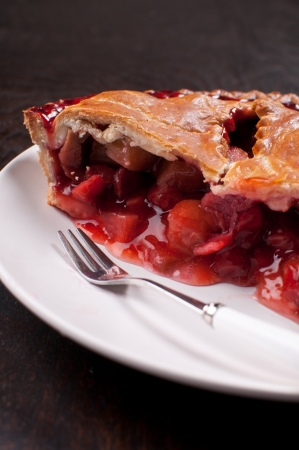 Eating rhubarb and strawberry tart pie with forkの写真素材