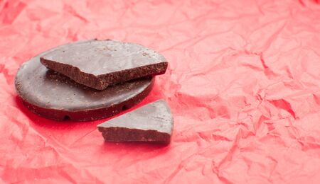 Dark chocolate on red holiday background with copy spaceの写真素材