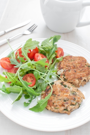 Fish patties with parsley and arugula tomato salad dinnerの写真素材