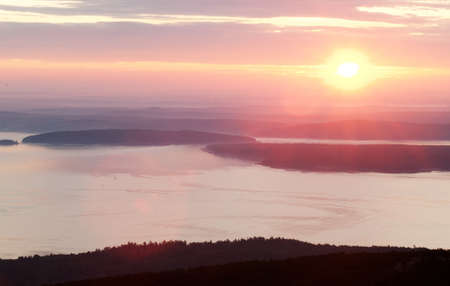Pink sunrise in mountain and sea or ocean shoreの写真素材