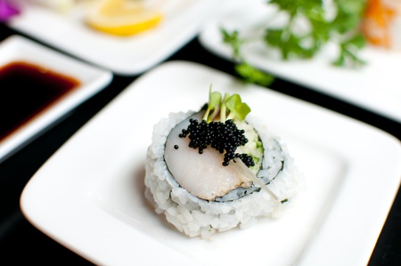 Scallop sushi roll on plate with black roeの写真素材