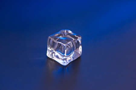 An ice cube on the blue background
