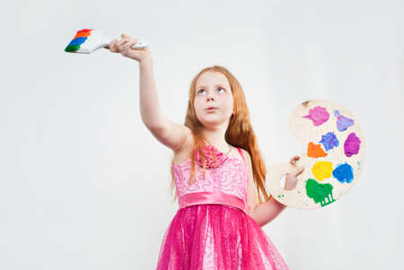 Beautiful little girl playing with bright watercolourの写真素材