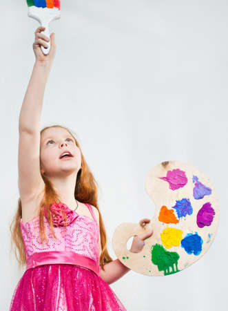 Beautiful little girl playing with bright watercolourの写真素材
