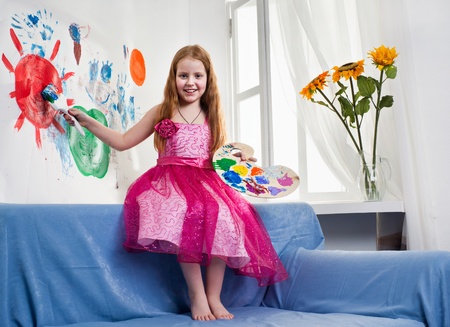 Beautiful little girl playing with bright watercolourの写真素材