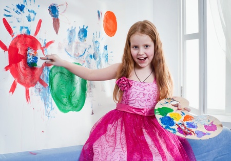 Beautiful little girl playing with bright watercolourの写真素材