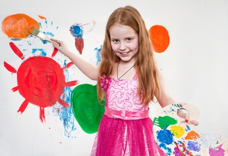 Beautiful little girl playing with bright watercolourの写真素材