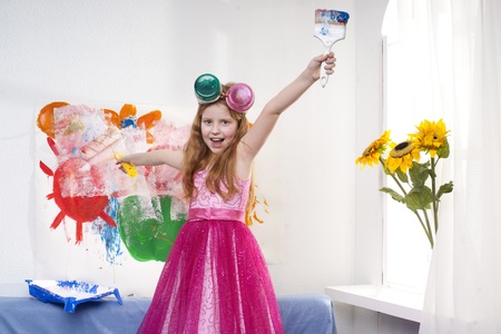 Beautiful little girl playing with bright watercolourの写真素材