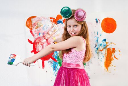 Beautiful little girl playing with bright watercolourの写真素材