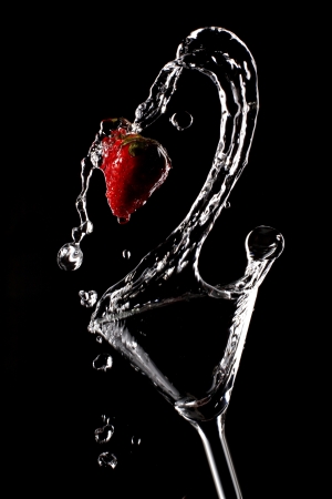 Cocktail with strawberry spilling from the glassの写真素材