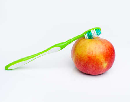 Green toothbrush is on ripe appleの写真素材