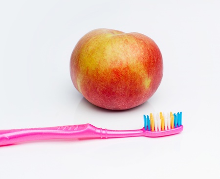 Green toothbrush is on ripe appleの写真素材
