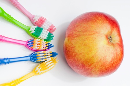 Beautiful background of colored toothbrushes and appleの写真素材