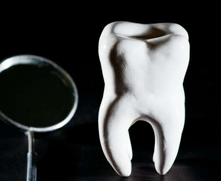 tooth and medical mirror on black backgroundの写真素材