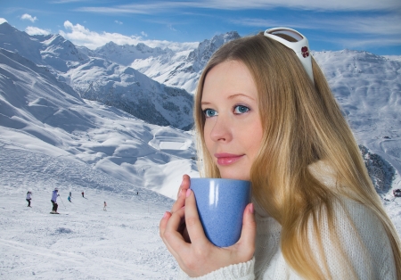 Blonde with a mug on background of the mountainsの写真素材