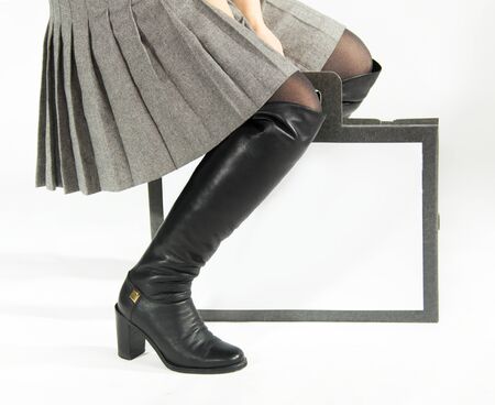 Black boots, pleated skirt and bagの写真素材