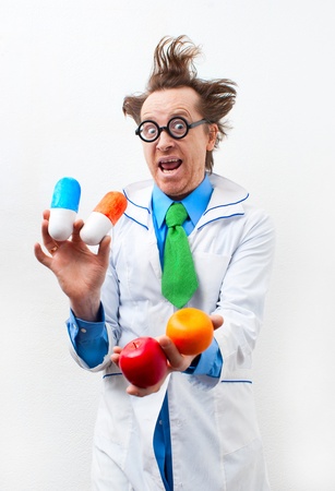 Funny doctor with tablet and fruit in handの写真素材