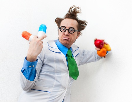 Amazed doctor with tablet and fruit in handの写真素材