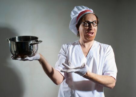 Funny chef with pan on gray backgroundの写真素材