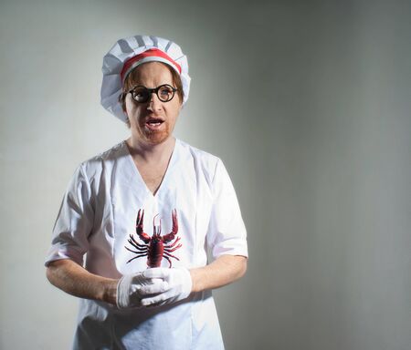 Funny chef with lobster on gray backgroundの写真素材