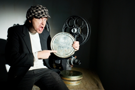 Funny projectionist and film projector with filmの写真素材