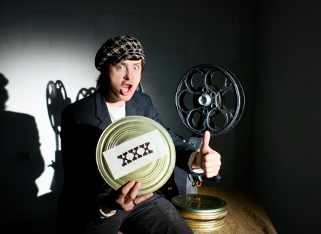 Funny projectionist and film projector with filmの写真素材