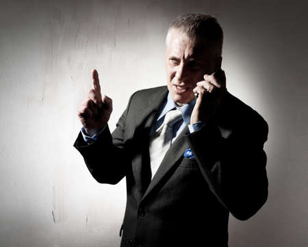 Serious businessman with a cellular phoneの写真素材