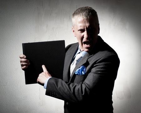 Angry businessman with business book