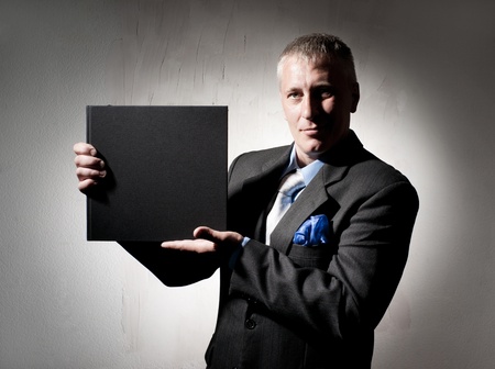 Serious businessman with business bookの写真素材