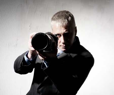 Professional photographer in a suit with a cameraの写真素材