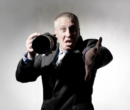 Emotional photographer in a suit with a cameraの写真素材