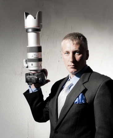 Portrait of photographer in a suit with a camera の写真素材