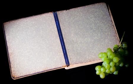 Old book and grapes on black backgroundの写真素材