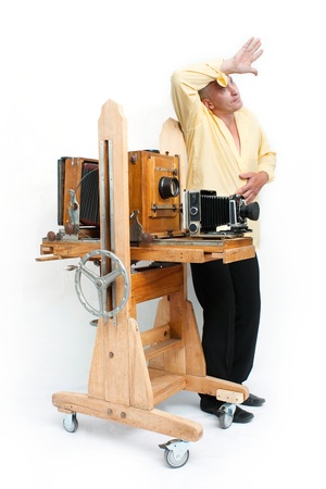 Weary photographer in yellow shirt with retro cameraの写真素材