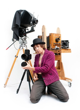 Creative photographer in pink coat with retro cameraの写真素材