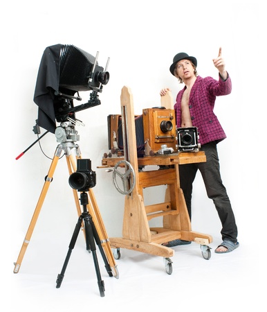 Creative photographer in pink coat with retro cameraの写真素材