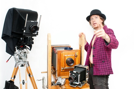 Creative photographer in pink coat with retro cameraの写真素材