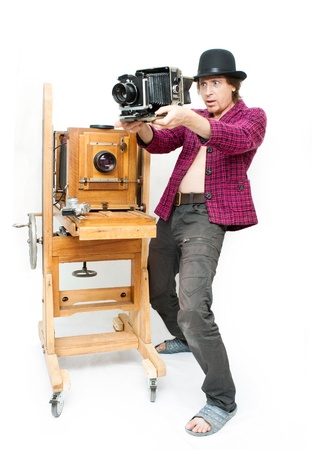 Creative photographer in pink coat with retro cameraの写真素材