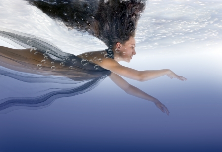 Beautiful naked girl swims under waterの写真素材