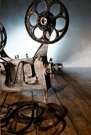 Movie projector with the film on the wooden floorの写真素材