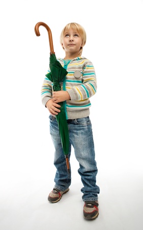Little boy with a closed green umbrellaの写真素材