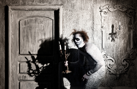 Scary ghost with a candlestick in the old houseの写真素材
