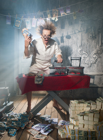 Crazy counterfeiter dries and ironed currencyの写真素材