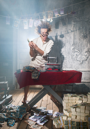 Crazy counterfeiter dries and ironed currencyの写真素材