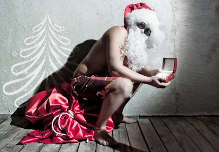 Funny Santa Claus holding a giftの写真素材