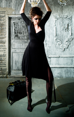 Slender stylish girl in the black dressの写真素材