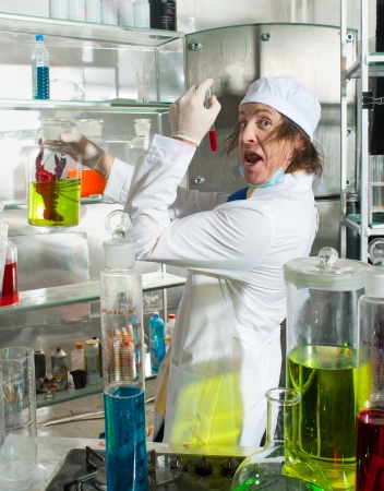 Cheerful chemist puts science experiment in laboratoryの写真素材
