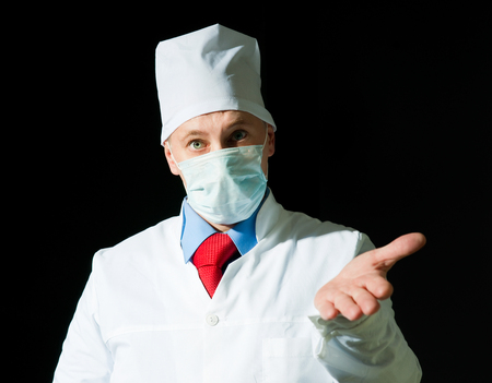Portrait of doctor in surgical mask on black の写真素材